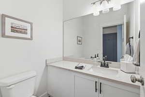Half bathroom with toilet and vanity