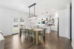 Dining room with dark wood-type flooring and recessed lighting