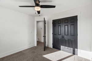 Unfurnished bedroom featuring a closet, carpet flooring, and a ceiling fan