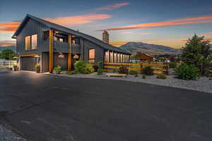 View of front facade featuring board and batten siding, a garage, a balcony, driveway, and a mountain view
