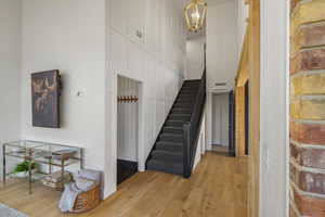 Stairway featuring wood-type flooring, hanging lights, and a high ceiling