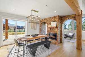 Dining room with light wood-type flooring, plenty of natural light, a fireplace, and a mountain view
