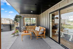 Balcony featuring a hot tub and an outdoor living space