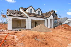 Unfinished property with a garage and a patio