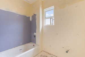Full bathroom featuring a tub to relax in