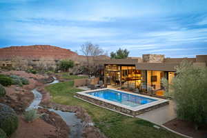 Swimming pool featuring a lawn, a patio area, and a mountain view