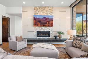 Living area with wood finished floors, a fireplace, and recessed lighting