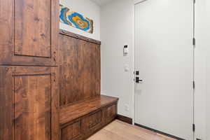 Mudroom featuring light wood-style flooring and baseboards