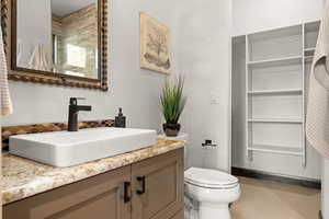 Bathroom with vanity, light tile patterned floors, decorative backsplash, and a closet