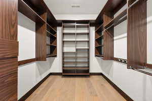 Walk in closet with light wood-type flooring