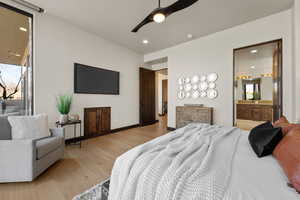 Bedroom with light wood-style floors, a ceiling fan, recessed lighting, and ensuite bath