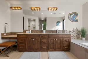 Full bathroom with double vanity, decorative backsplash, a bath, and recessed lighting