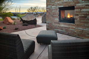 Patio terrace at dusk featuring an outdoor stone fireplace and a patio