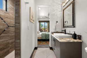 Ensuite bathroom featuring vanity, light tile patterned floors, recessed lighting, and walk in shower