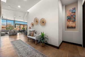 Corridor with hardwood / wood-style floors, floor to ceiling windows, and recessed lighting
