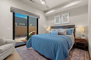 Bedroom featuring access to exterior, wood finished floors, and a ceiling fan