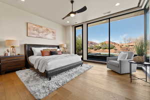 Bedroom featuring light wood finished floors, floor to ceiling windows, a ceiling fan, a mountain view, and recessed lighting