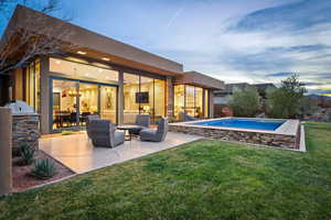 View of swimming pool with an outdoor kitchen and patio surround