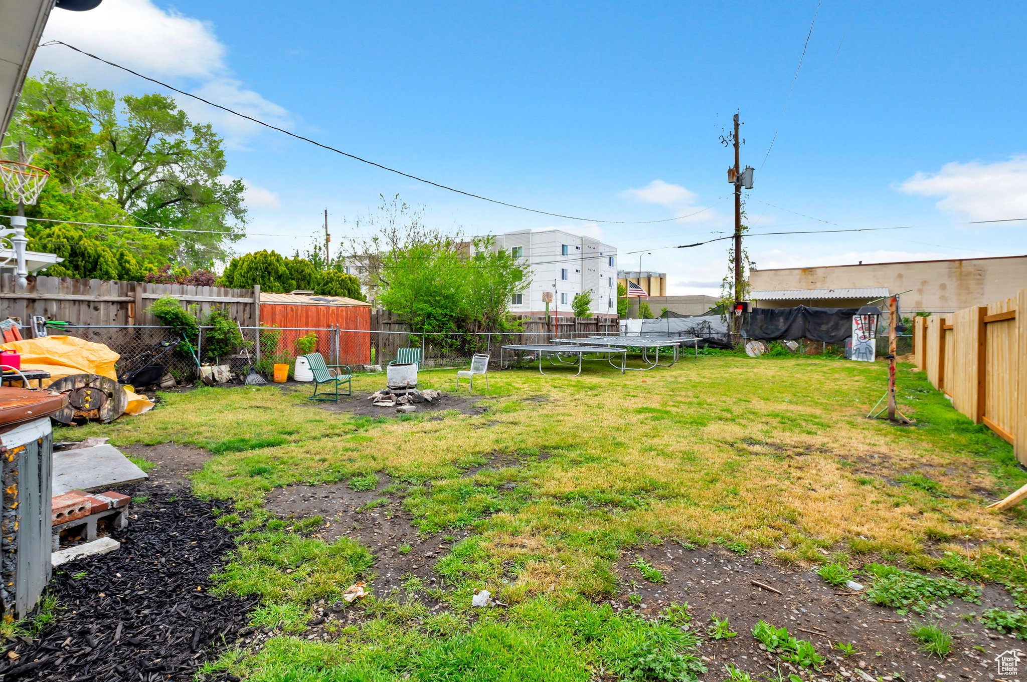 Fenced backyard featuring a trampoline