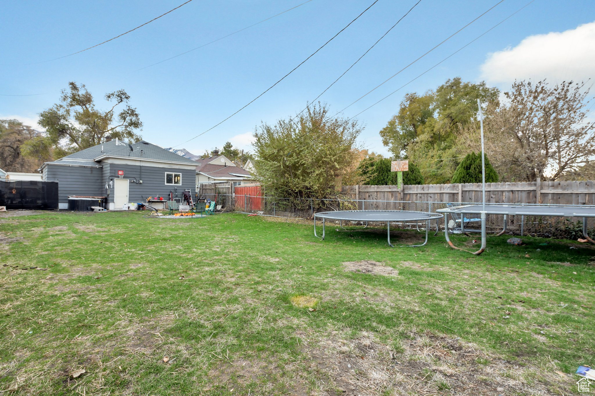 Fenced backyard featuring a trampoline