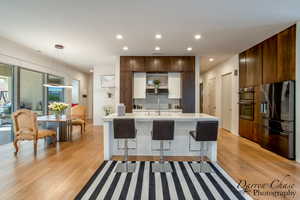Kitchen with modern cabinets, stainless steel appliances, a breakfast bar area, and two tone color scheme