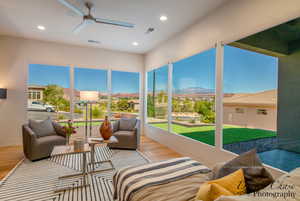 Sunroom / solarium with a residential view, a mountain view, wood finished floors, and recessed lighting