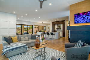 Living area with light wood-style floors, a ceiling fan, and recessed lighting