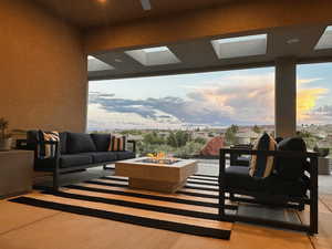 View of patio featuring an outdoor living space with a fire pit and a residential view
