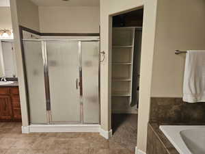 Bathroom with vanity, a shower stall, and a garden tub