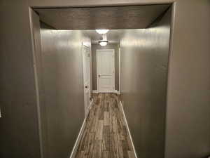 Corridor featuring baseboards and dark wood finished floors