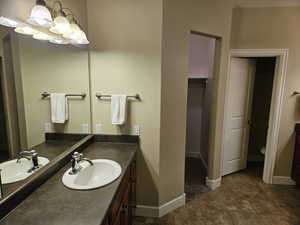 Full bathroom featuring vanity and a walk in closet