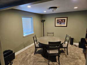 Carpeted dining space featuring recessed lighting and a textured ceiling
