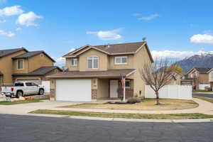 Traditional home with roof with shingles, a residential view, driveway, stucco siding, and a garage