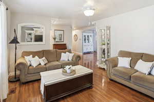 Living area featuring dark wood-type flooring and a ceiling fan