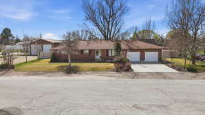 Ranch-style house with concrete driveway and an attached garage
