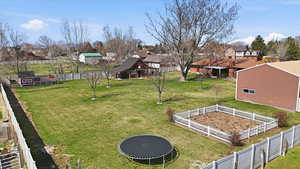 View of yard with a trampoline, a residential view, and an outbuilding