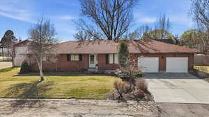 Ranch-style house featuring driveway, a front yard, an attached garage, and a shingled roof