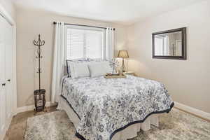 Carpeted bedroom with baseboards and a closet