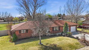 View of front of property featuring brick siding, concrete driveway, roof with shingles, and an attached garage
