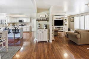 Living room with dark wood-style floors and ceiling fan