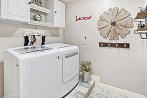 Laundry area with electric panel, cabinet space, and independent washer and dryer