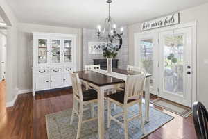 Dining space with dark wood-type flooring and a chandelier