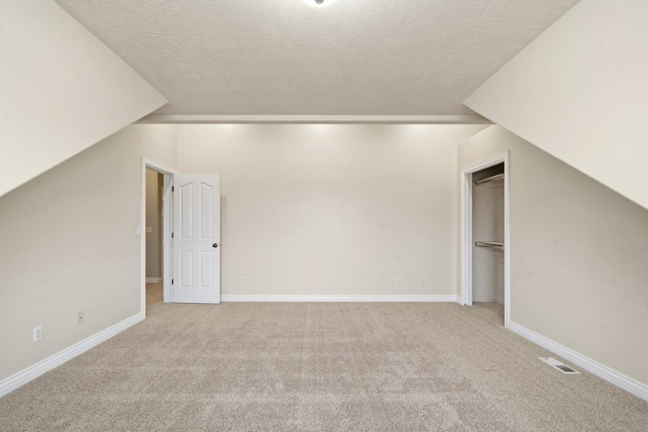 Bonus room featuring light colored carpet