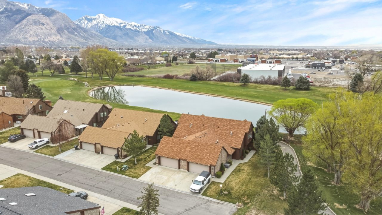 Aerial perspective of suburban area with a water and mountain view and a golf course