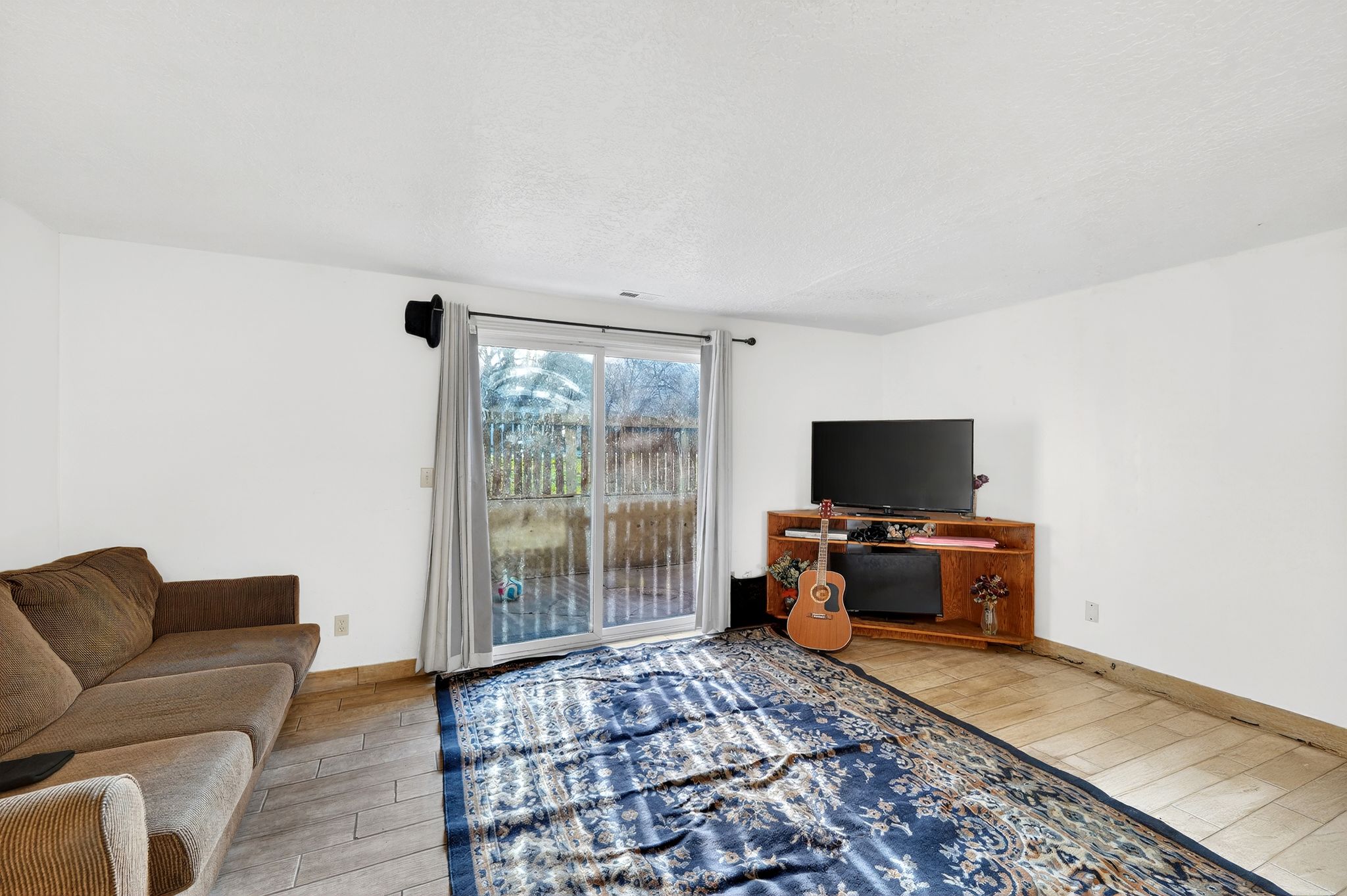 Living area featuring light wood finished floors and a textured ceiling