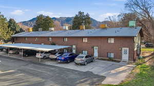 Back of house featuring a mountain view, covered parking, and brick siding