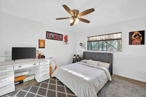 Bedroom with a ceiling fan and baseboards