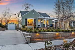 Bungalow-style house featuring an outbuilding, a garage, roof with shingles, and driveway