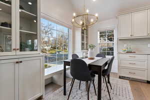Dining area with suspended lighting and light wood finished floors
