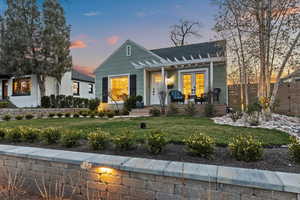 Bungalow-style house with a shingled roof and french doors
